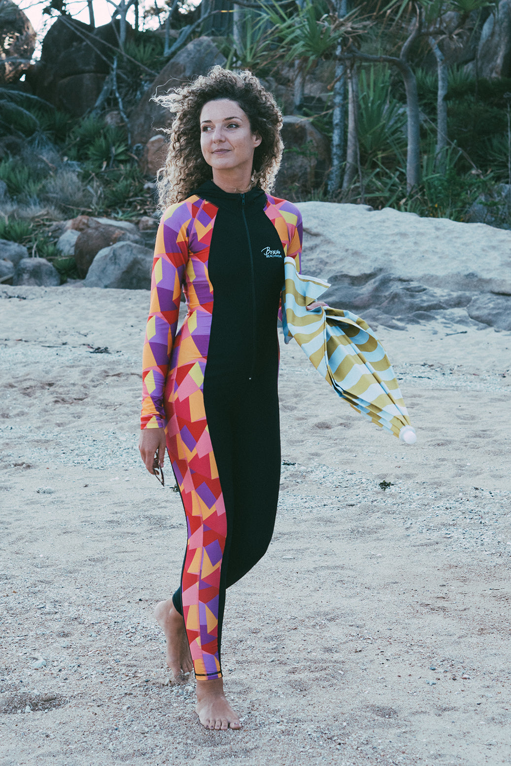 Female in stingersuit on beach with umbrella