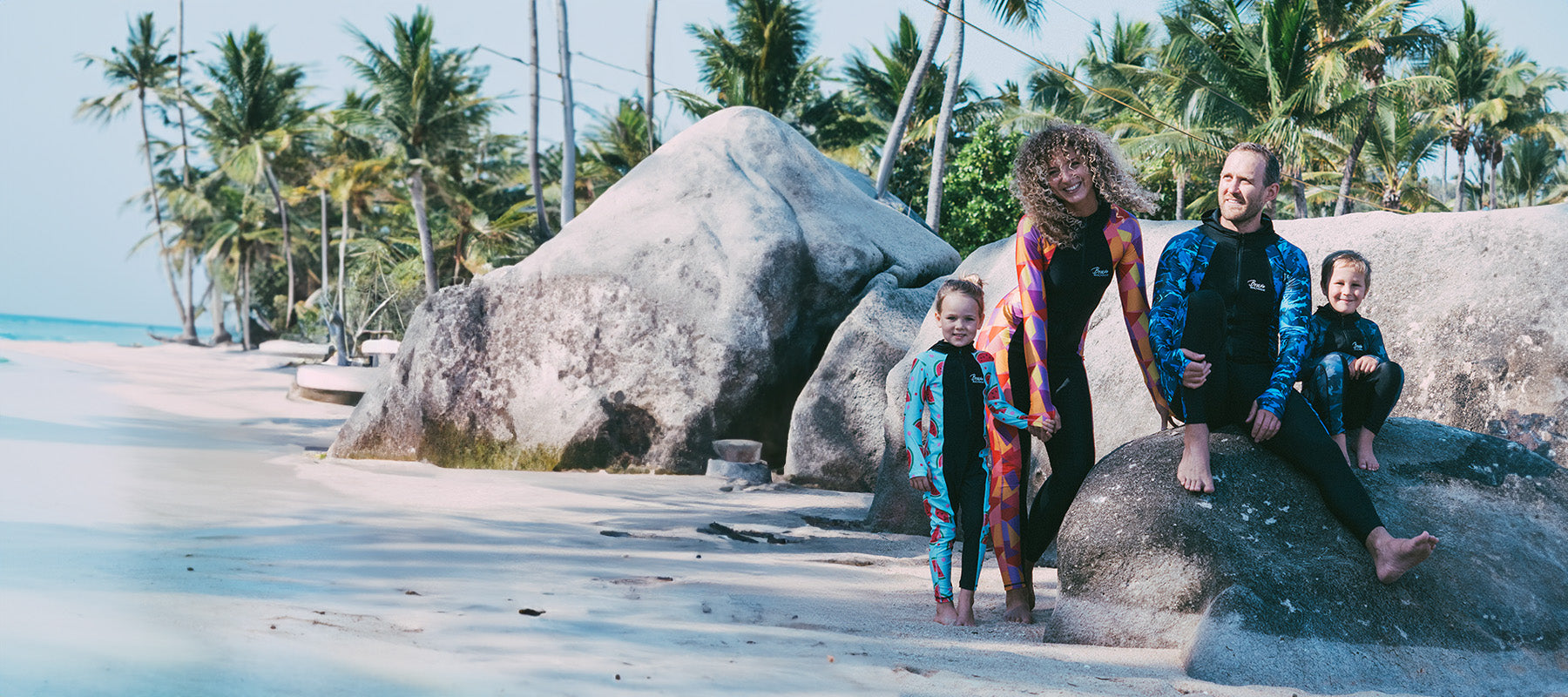 Family in Stingersuits sitting on Magnetic Island Rocks